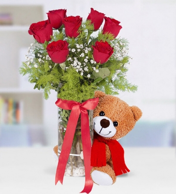 7 adet kırmızı gül, 1 adet gülen peluş ayıcık ile hazırlanmıştır.